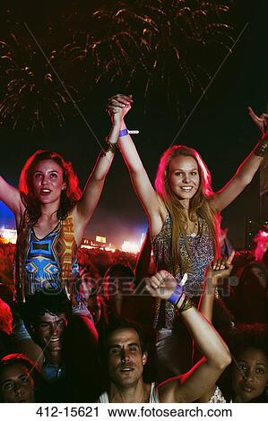 Cheering women on men's shoulders at music festival View Large Photo Image Stock Image - Cheering women on men's shoulders at music festival. Fotosearch