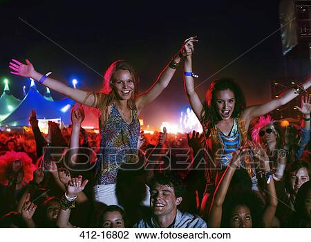 Cheering women on men's shoulders at music festival View Large Photo Image Stock Image - Cheering women on men's shoulders at music festival. Fotosearch