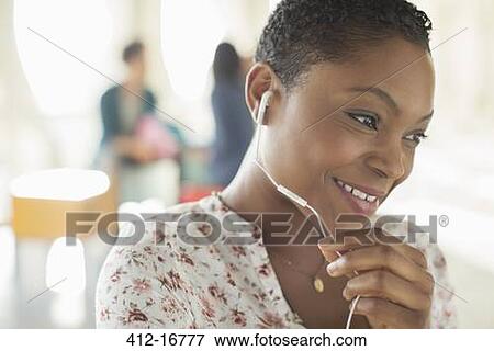 Close up of smiling woman using hands-free device View Large Photo Image Stock Photo - Close up of smiling woman using hands-free device. Fotosearch
