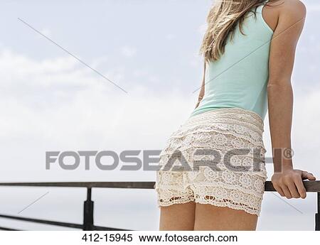 Close up of woman in shorts leaning on balcony railing View Large Photo Image Stock Photography - Close up of woman in shorts leaning on balcony railing. Fotosearch