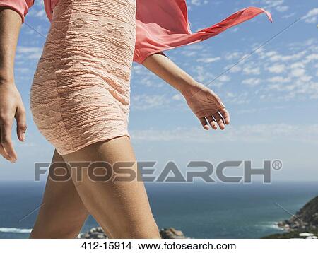 Close up of woman walking with ocean in background View Large Photo Image Picture - Close up of woman walking with ocean in background. Fotosearch