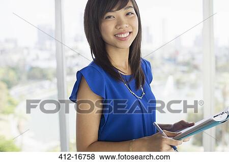 Stock Photo - Close up portrait of confident businesswoman with paperwork. Fotosearch