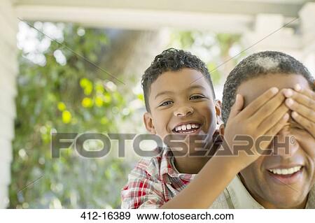 Stock Photo - Close up portrait of grandson surprising grandfather. Fotosearch