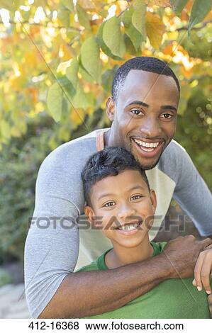 Close up portrait of smiling father and son View Large Photo Image Stock Photo - Close up portrait of smiling father and son. Fotosearch