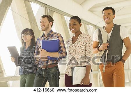 Stock Image - Confident casual business people walking in office corridor. Fotosearch