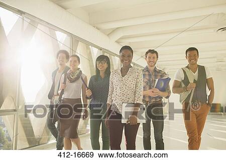 Stock Photo - Confident creative business people walking in sunny corridor. Fotosearch