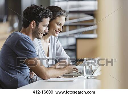 Couple using laptop at table View Large Photo Image Stock Image - Couple using laptop at table. Fotosearch