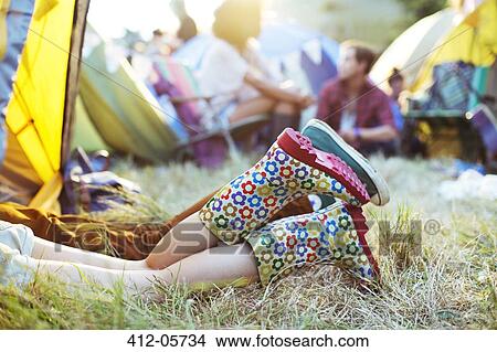 Picture - Couple's legs sticking out of tent at music festival. Fotosearch