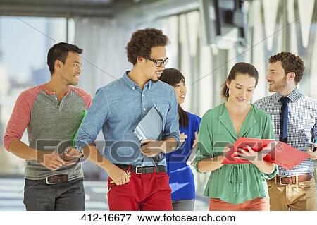 Stock Photo - Creative business people walking in office corridor. Fotosearch