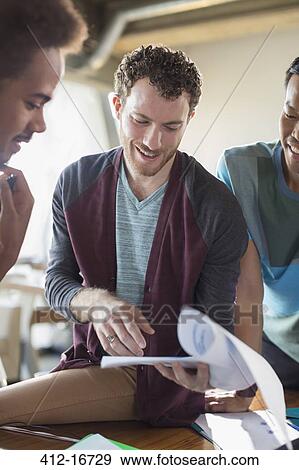 Creative businessmen discussing paperwork in meeting View Large Photo Image Stock Photo - Creative businessmen discussing paperwork in meeting. Fotosearch