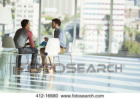 Creative businessmen meeting at circle of chairs in sunny office View Large Photo Image Stock Image - Creative businessmen meeting at circle of chairs in sunny office. Fotosearch