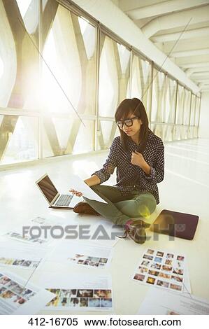 Creative businesswoman looking at photograph proofs on office floor View Large Photo Image Stock Photography - Creative businesswoman looking at photograph proofs on office floor. Fotosearch