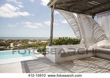Curtains blowing in wind on luxury poolside patio overlooking ocean View Large Photo Image Stock Image - Curtains blowing in wind on luxury poolside patio overlooking ocean. Fotosearch