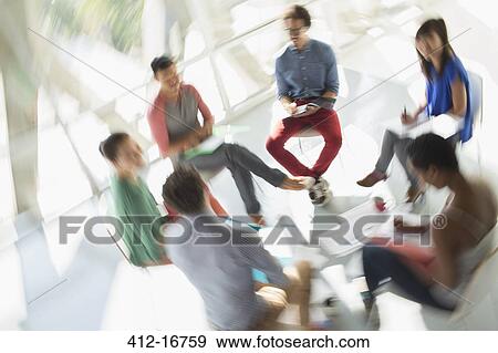 Defocused view of creative business people meeting in circle of chairs View Large Photo Image Stock Photo - Defocused view of creative business people meeting in circle of chairs. Fotosearch