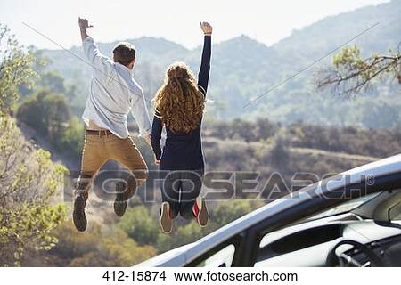Enthusiastic couple jumping for joy outside car View Large Photo Image Picture - Enthusiastic couple jumping for joy outside car. Fotosearch