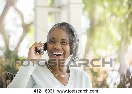 Enthusiastic senior woman talking on telephone on porch View Large Photo Image Stock Image - Enthusiastic senior woman talking on telephone on porch. Fotosearch