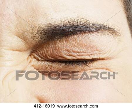 Stock Photo - Extreme close up of girl squinting eye. Fotosearch