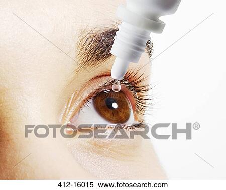 Stock Photography - Extreme close up of woman putting eye drops into eye. Fotosearch