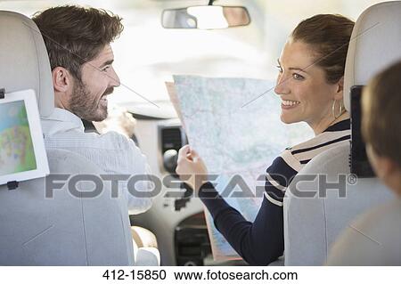 Stock Image - Family with map inside car. Fotosearch