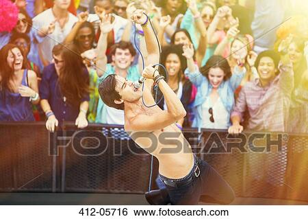 Fans cheering for performer singing on stage View Large Photo Image Stock Photograph - Fans cheering for performer singing on stage. Fotosearch