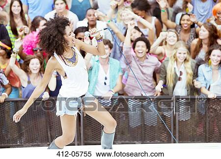 Fans cheering for performer singing on stage at music festival View Large Photo Image Stock Photography - Fans cheering for performer singing on stage at music festival. Fotosearch