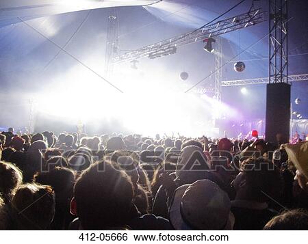 Fans facing illuminated stage at music festival View Large Photo Image Stock Photograph - Fans facing illuminated stage at music festival. Fotosearch