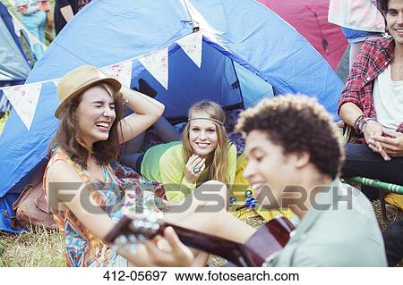 Friends hanging out at tent at music festival View Large Photo Image Stock Photo - Friends hanging out at tent at music festival. Fotosearch