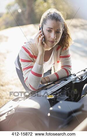 Frustrated woman talking on cell phone and looking at car engine View Large Photo Image Stock Image - Frustrated woman talking on cell phone and looking at car engine. Fotosearch