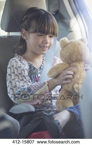 Girl with teddy bear in back seat of car View Large Photo Image Stock Photo - Girl with teddy bear in back seat of car. Fotosearch