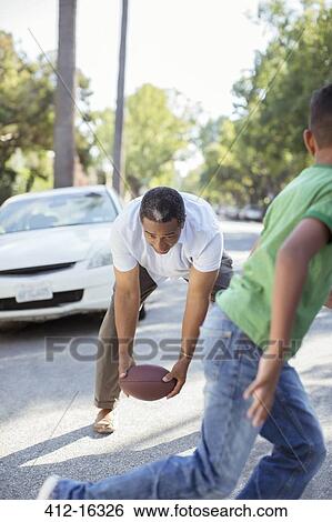 Grandfather and grandson playing football in street View Large Photo Image Stock Photograph - Grandfather and grandson playing football in street. Fotosearch