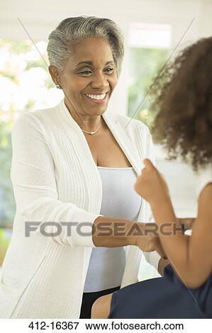 Grandmother smiling at granddaughter View Large Photo Image Stock Photo - Grandmother smiling at granddaughter. Fotosearch