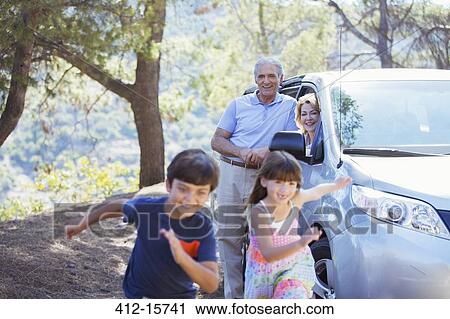 Grandparents watching grandchildren running outside car View Large Photo Image Stock Image - Grandparents watching grandchildren running outside car. Fotosearch