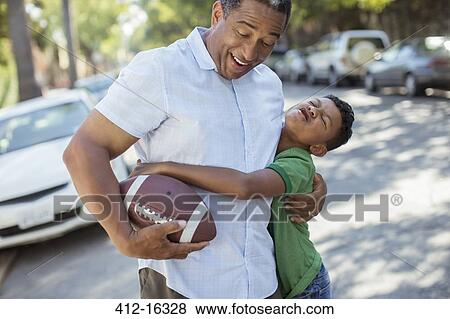 Grandson tackling grandfather with football View Large Photo Image Stock Photo - Grandson tackling grandfather with football. Fotosearch