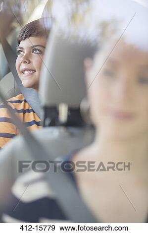 Happy boy looking at window from back seat of car View Large Photo Image Stock Photo - Happy boy looking at window from back seat of car. Fotosearch