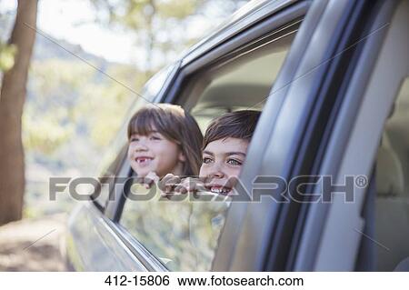 Happy brother and sister looking out car window View Large Photo Image Stock Photograph - Happy brother and sister looking out car window. Fotosearch