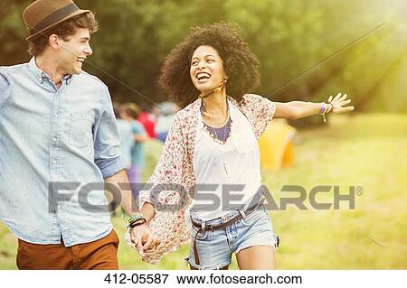 Happy couple in field outside tents at music festival View Large Photo Image Stock Photo - Happy couple in field outside tents at music festival. Fotosearch