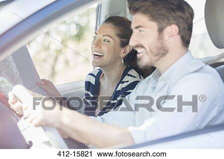 Happy couple with map driving in car View Large Photo Image Stock Image - Happy couple with map driving in car. Fotosearch