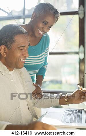 Happy senior couple using laptop View Large Photo Image Stock Image - Happy senior couple using laptop. Fotosearch