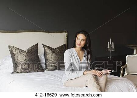 Happy woman using digital tablet in bedroom View Large Photo Image Stock Photo - Happy woman using digital tablet in bedroom. Fotosearch