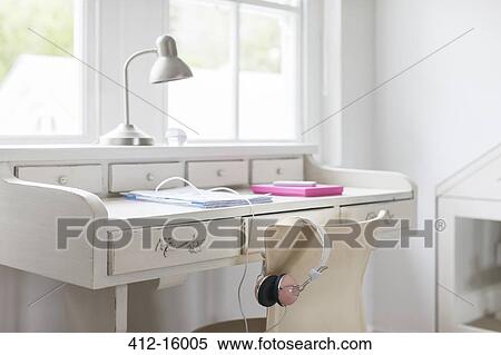 Headphones hanging on chair at white desk View Large Photo Image Stock Photography - Headphones hanging on chair at white desk. Fotosearch