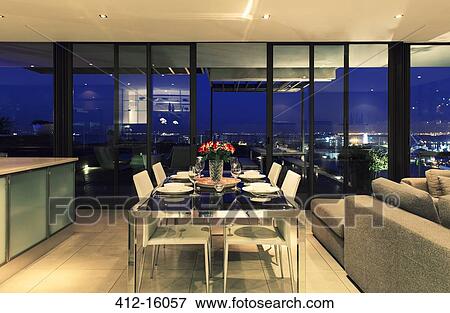 Illuminated modern dining room overlooking city View Large Photo Image Stock Photo - Illuminated modern dining room overlooking city. Fotosearch