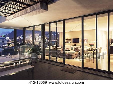 Illuminated modern living room and patio View Large Photo Image Stock Photo - Illuminated modern living room and patio. Fotosearch