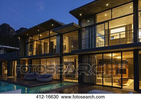 Luxury house with swimming pool illuminated at night View Large Photo Image Stock Image - Luxury house with swimming pool illuminated at night. Fotosearch