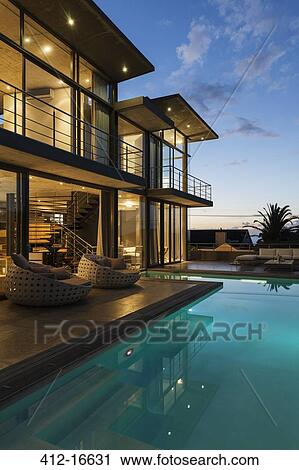 Luxury house with swimming pool illuminated at night View Large Photo Image Stock Image - Luxury house with swimming pool illuminated at night. Fotosearch