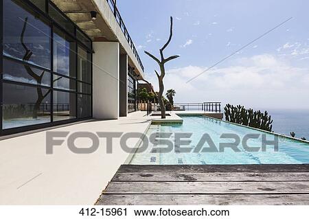 Stock Image - Luxury lap pool overlooking ocean. Fotosearch
