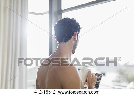 Man drinking coffee at window View Large Photo Image Stock Image - Man drinking coffee at window. Fotosearch