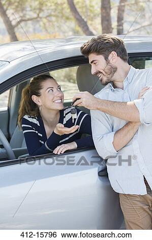 Stock Photograph - Man giving woman in car keys. Fotosearch