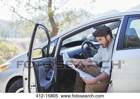 Man in car looking at map View Large Photo Image Stock Photography - Man in car looking at map. Fotosearch