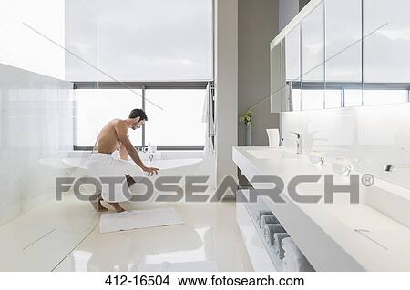 Man in towel preparing bath View Large Photo Image Picture - Man in towel preparing bath. Fotosearch