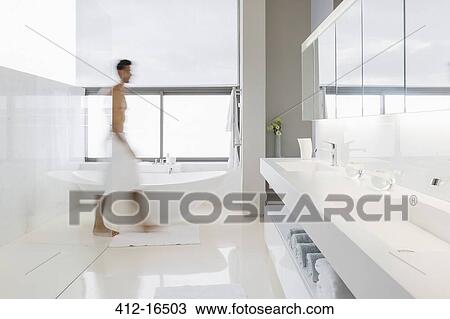 Man in towel walking in bathroom View Large Photo Image Stock Image - Man in towel walking in bathroom. Fotosearch